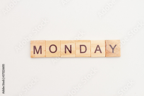 Word MONDAY made from wooden cubes on white. Days of the week. First day