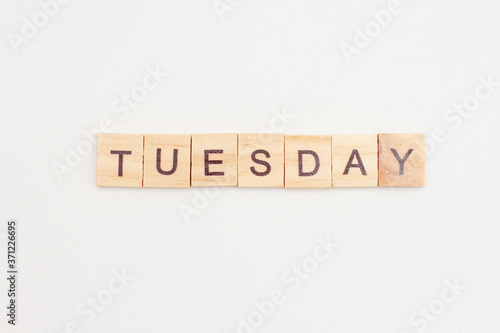 Word TUESDAY made from wooden cubes on white. Days of the week