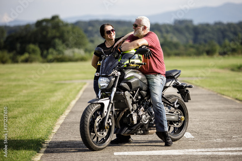 A middle-aged man and his girl friend enjoys with his motorcycle © romul014
