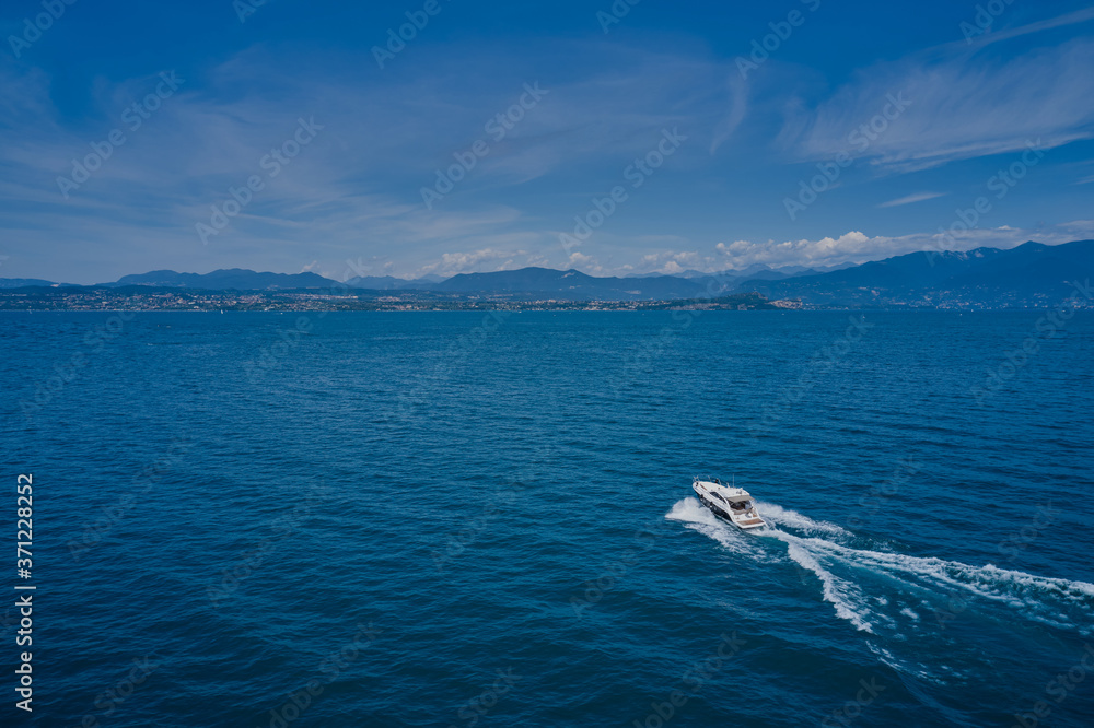 Top view of a white boat sailing in blue water. Motor boat in the lake. Travel - image