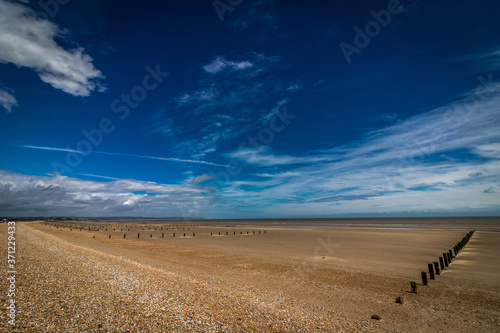 Groynes on a deserted beach at Dymchurch, Kent, England photo