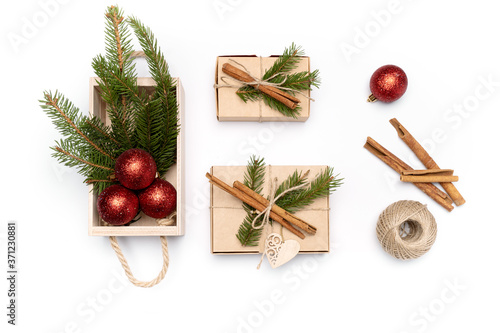 Flat lay craft boxes with fir tree, cinnamon and rope and wooden box with fir tree and New Year balls on white background. High quality photo