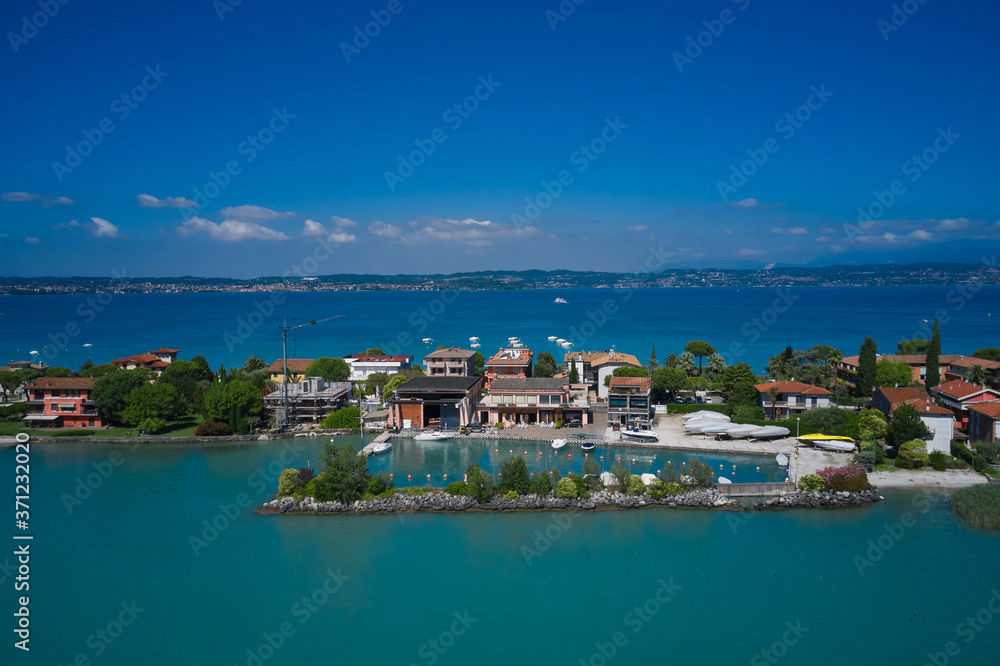 View by Drone. Aerial view on Sirmione sul Garda. Italy, Lombardy. Parking for boats in Sirmione