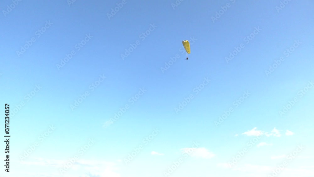 Paraglider flying in the air stream. Paraglider floating in the air against the sky. Close-up / Parachute close-up. Yellow paraglider against a blue sky background
Paraglider flying in the air stream. Paraglider floating in the air against the sky. Close-up / Parachute close-up. Yellow paraglider against a blue sky background