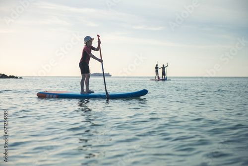 Happy teen girl paddling on sup board in Baltic sea © spass