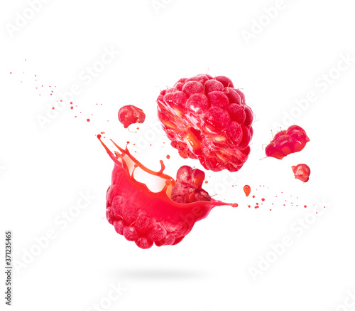 Fotografia Raspberry cut into two halves with flowing juice close-up on white background