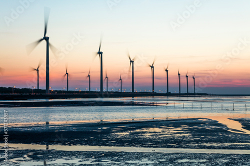 sunset view of Gaomei wetlands landscape and the wind power plant in Taichung, Taiwan. energy systems and renewable energy. photo