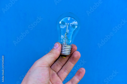Glittering incandescent lamps in hand on a blue background