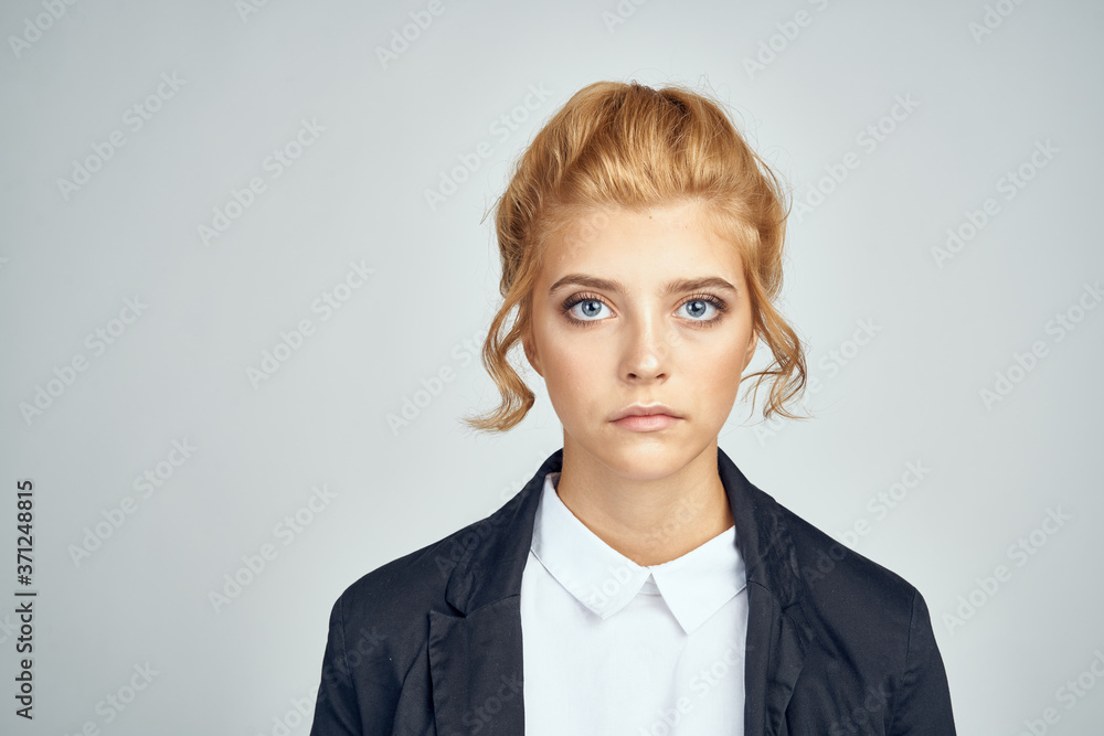 Portrait of a female businesswoman in a white shirt and a blonde model in a jacket on a light background Portrait of a female businesswoman in a white shirt and a blonde model in a jacket on a light background