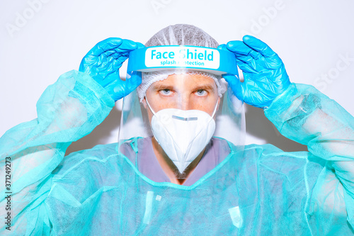 Portrait of healthcare professional adjusting face shield