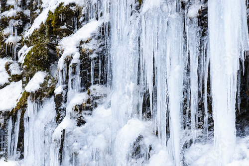 Frozen ice waterfall of blue icicles on the rock © BINGJHEN