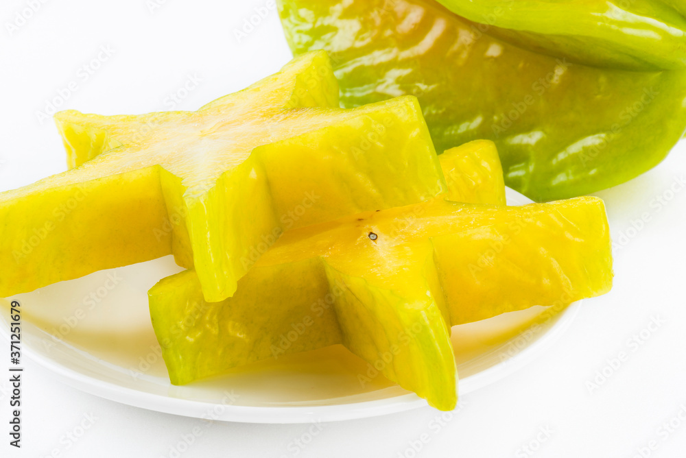 Sliced carambola on a white dish, it is a sweet and juicy fruit. Sliced carambola on a white dish, it is a sweet and juicy fruit.