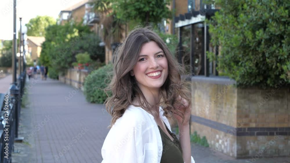 Slow motion shot of smiling brunette woman in city Slow motion shot of smiling brunette woman in city