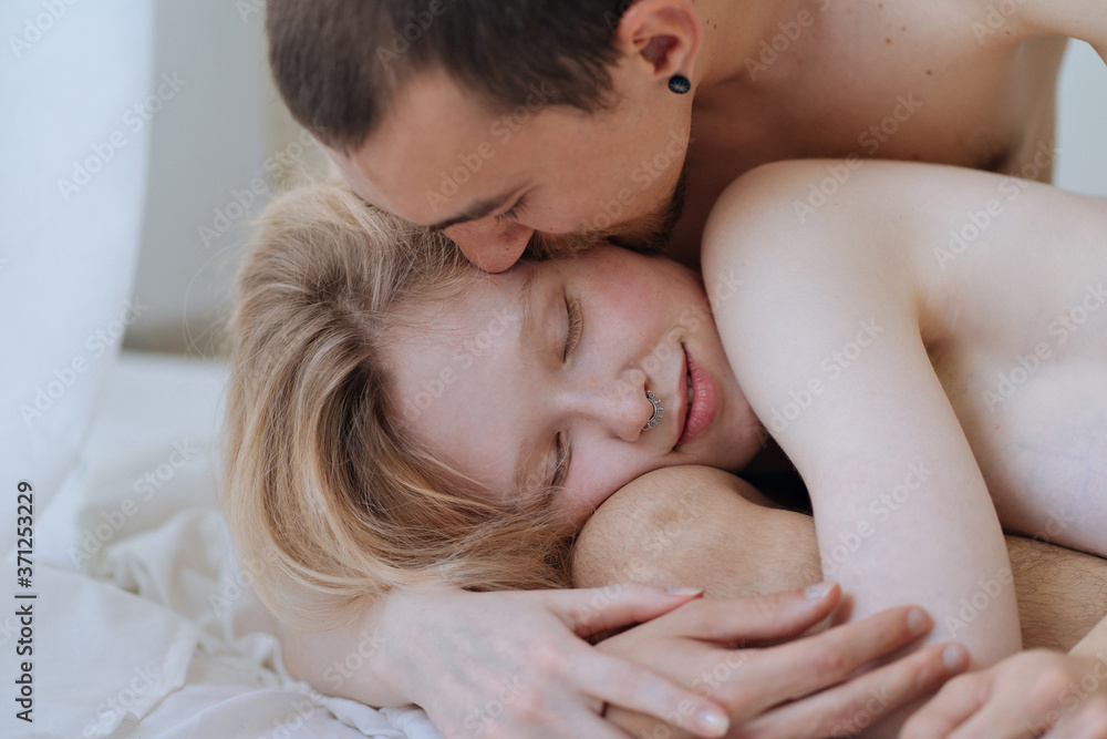 Young dark-haired guy kisses his girlfriend