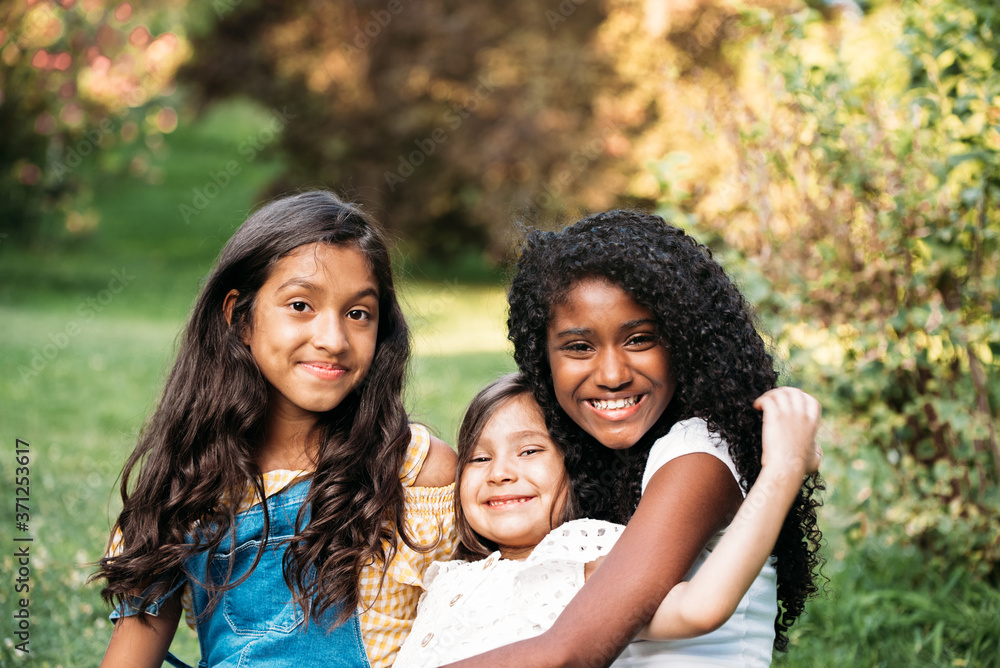 portrait of smiling ethnic girlfriends looking at camera portrait of smiling ethnic girlfriends looking at camera
