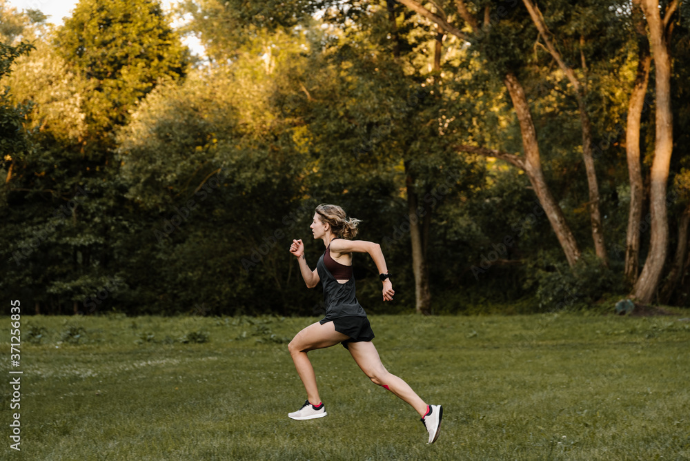 Young Athletic Woman Running Fast in the Park Young Athletic Woman Running Fast in the Park