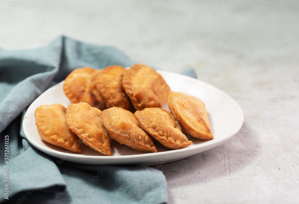 Typical Colombian empanadas usually served with spicy sauce on concrete surface Typical Colombian empanadas usually served with spicy sauce on concrete surface