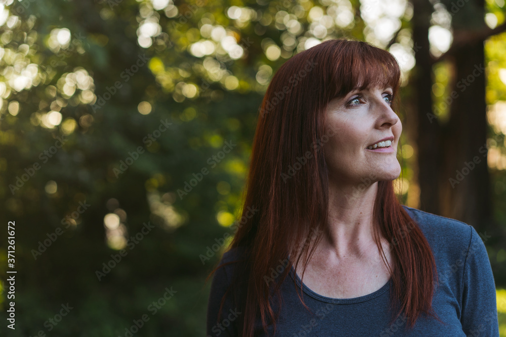 Vibrant middle age woman enjoying a warm evening outside in the Vibrant middle age woman enjoying a warm evening outside in the