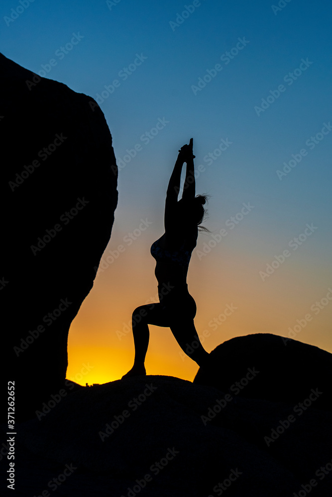 Woman doing Yoga pose in the sunset