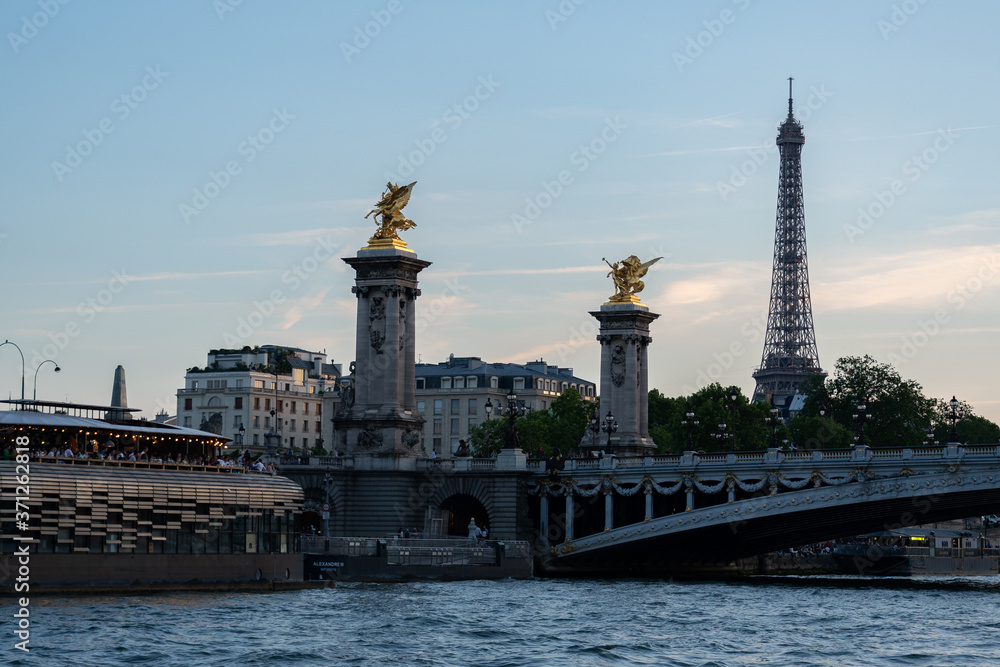 Fototapeta premium Famous Pont Alexandre III, giant towers with gilded Pegasus and Eiffel tower in background after sunset.