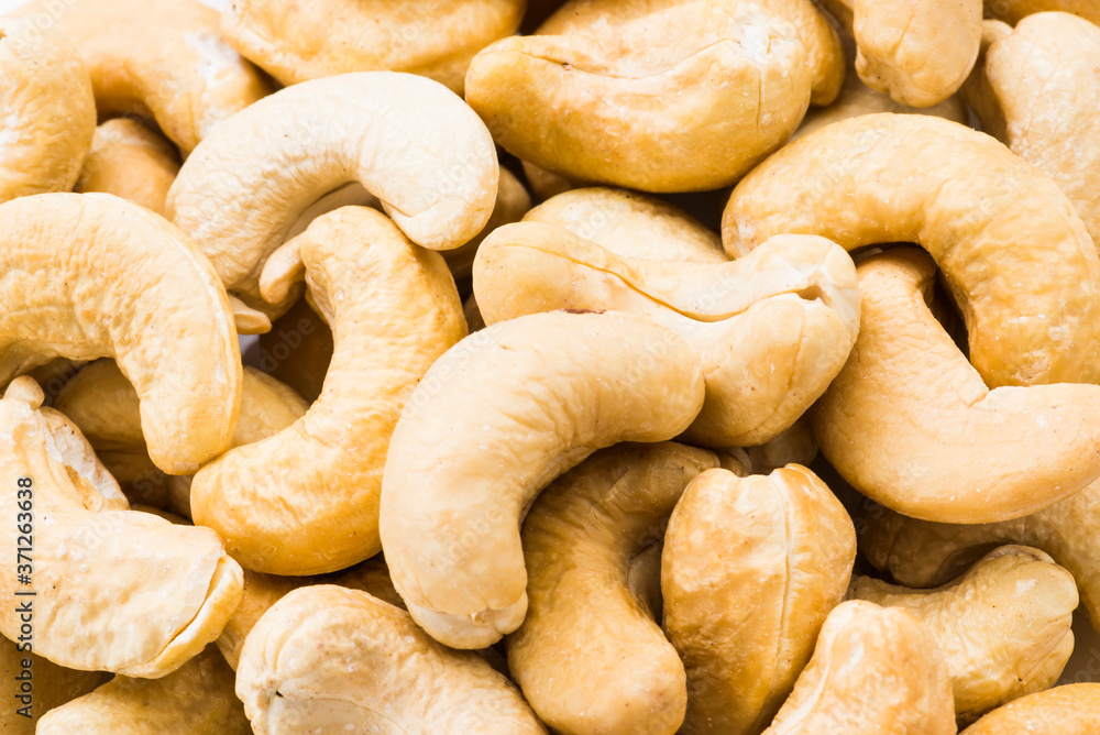 fresh cashew nuts on a white dish above the white background fresh cashew nuts on a white dish above the white background