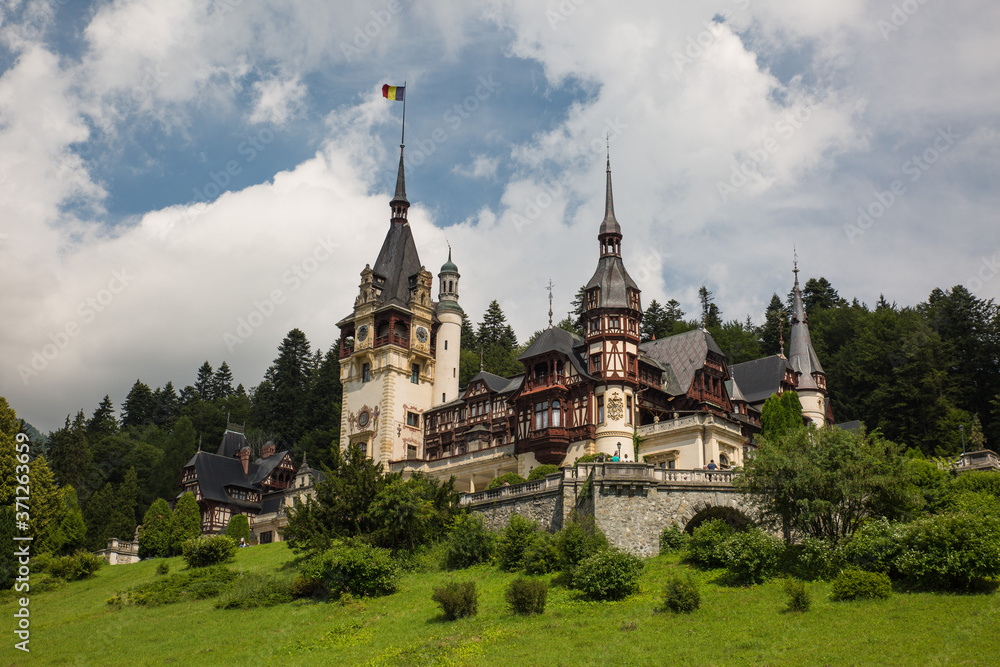 Panoramic view of Peles Castle, Romania. Famous Neo-Renaissance castle and ornamental garden in Sinaia, Carpathian Mountains in Europe.