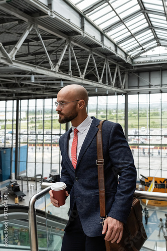 Wallpaper Mural Businessman with coffee on top of escalator in airport Torontodigital.ca