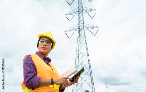 Electrical engineer women working on the tablet.Checking the power grids.