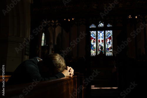 Man bows his head in prayer in Church.
