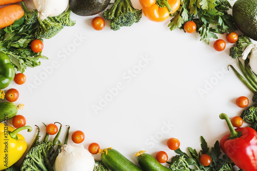 Assorted vegetables and fresh herbs on white background, top view. Plant based diet. Seasonal vegetables