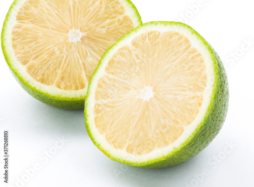 slice of fresh lemon that was cut in half isolated on white background