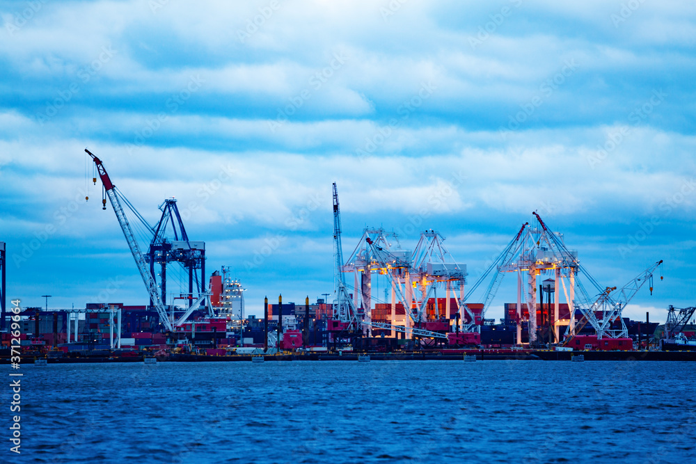 Marine cranes and containers for cargo ship at warehouse of maritime port in New York, NY, USA