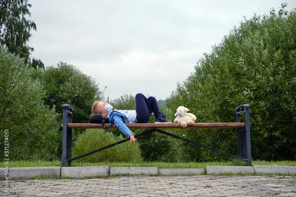 Fototapeta premium Little girl in a medical mask with her toy