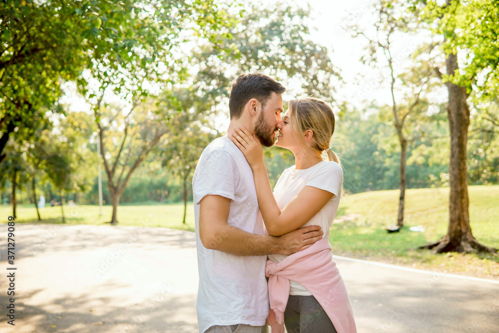 Happy couple flirting and kissing in summer park during workout. Romantic runners. Love, Relationship Fitness, sport and lifestyle concept. Happy couple flirting and kissing in summer park during workout. Romantic runners. Love, Relationship Fitness, sport and lifestyle concept.