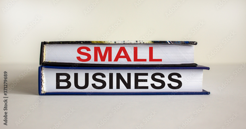 Obraz premium Books with text 'small business' on beautiful white table. White background. Business concept. Copy space.
