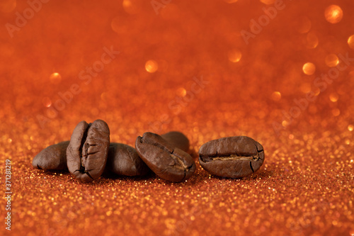 Coffee beans on trendy orange shiny background.