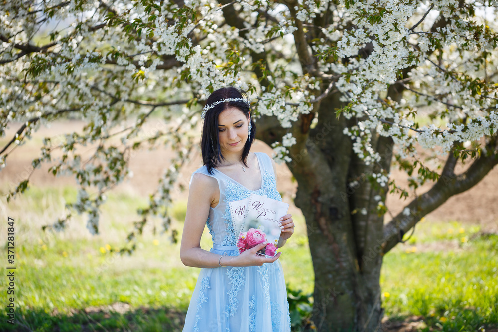 Young woman in a blue long dress holds a wedding glider in her hands Young woman in a blue long dress holds a wedding glider in her hands