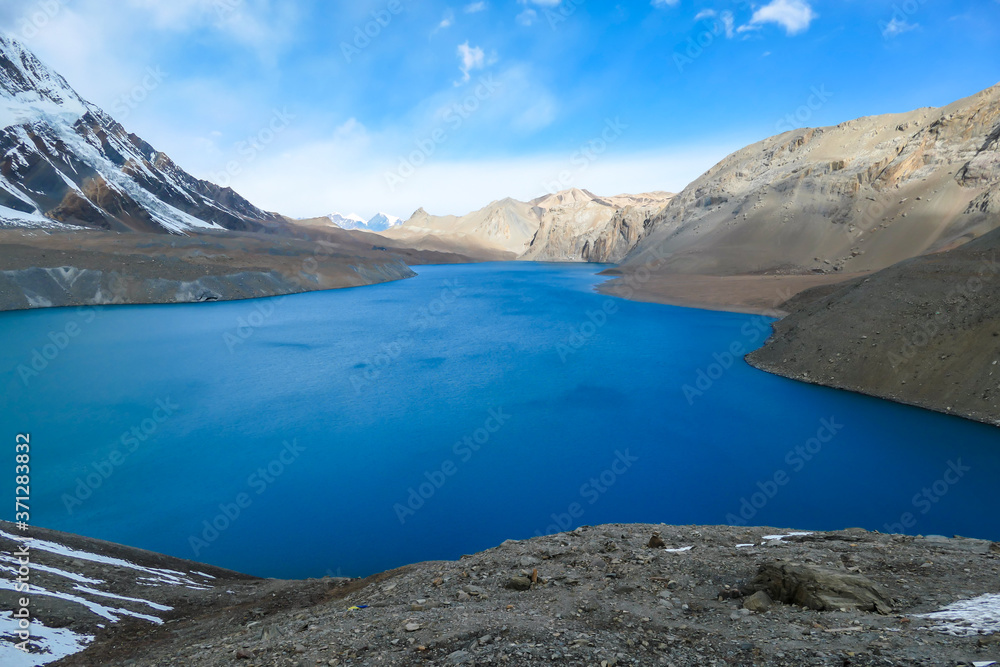 A panoramic view on turquoise colored Tilicho lake in Himalayas, Manang region in Nepal. The world's highest altitude lake (4949m). Snow capped mountains around. Calm surface of the lake. Serenity