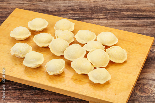 Raw dumplings over board for cooking