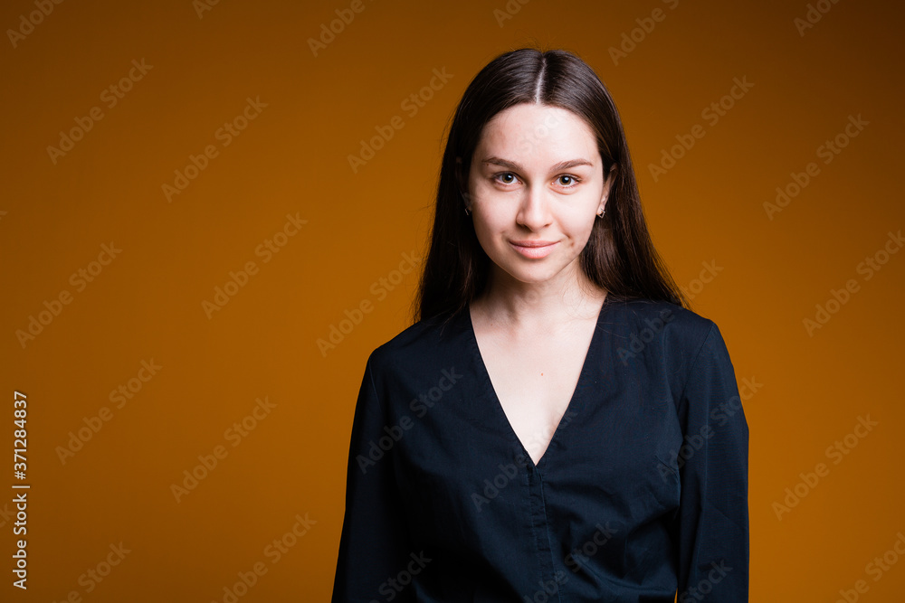 Portrait of a girl who stands and smiles on a yellow background Portrait of a girl who stands and smiles on a yellow background