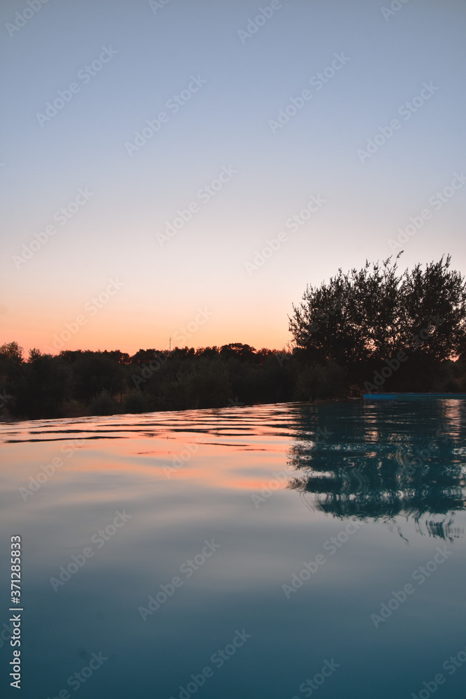 Foto del atardecer reflejado en una piscina