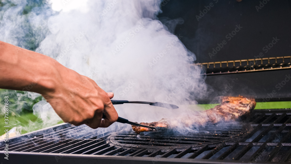 Home barbecue with charcoal in the backyard grilling steaks and other meats for carnivore diet. Home barbecue with charcoal in the backyard grilling steaks and other meats for carnivore diet.