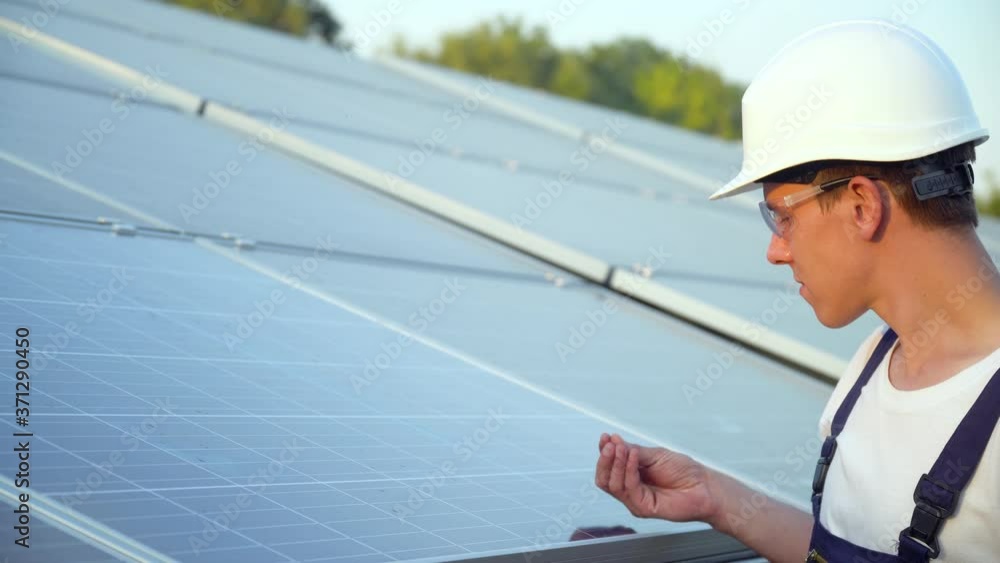 Young engineer is checking the operation of sun and cleanliness of photovoltaic solar panels. Concept renewable energy Young engineer is checking the operation of sun and cleanliness of photovoltaic solar panels. Concept renewable energy