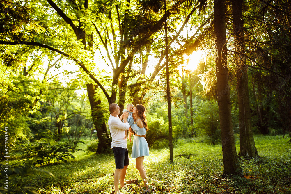 Loving parents with little baby girl walking at the park, hugging and smiling, tender mother hold adorable baby girl in arms, enjoy family weekend outdoors, parenthood concept Loving parents with little baby girl walking at the park, hugging and smiling, tender mother hold adorable baby girl in arms, enjoy family weekend outdoors, parenthood concept