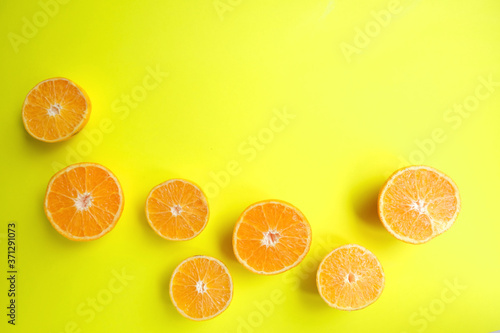 Orange still life. Fruit pattern of fresh orange slices on yellow background. Top view. Copy Space. Pop art design, creative summer concept. Half of citrus in minimal flat lay style. Banner