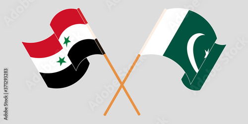 Crossed and waving flags of Syria and Pakistan