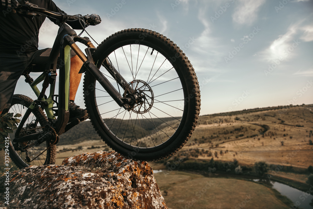 Fototapeta premium Crop cyclist with bike on cliff
