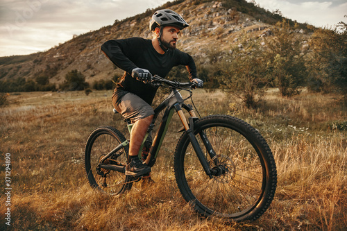 Bearded guy riding bicycle in valley