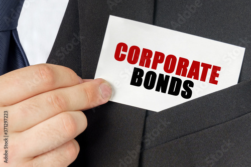 Businessman holds a card with the text - CORPORATE BONDS
