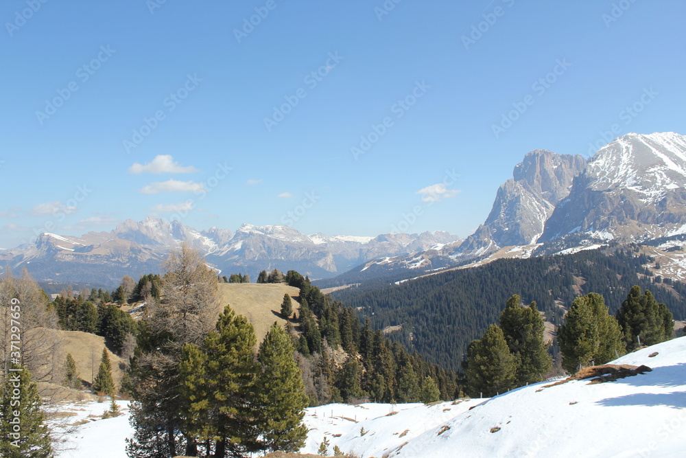 mountain view in late winter with blue sky and melting snow